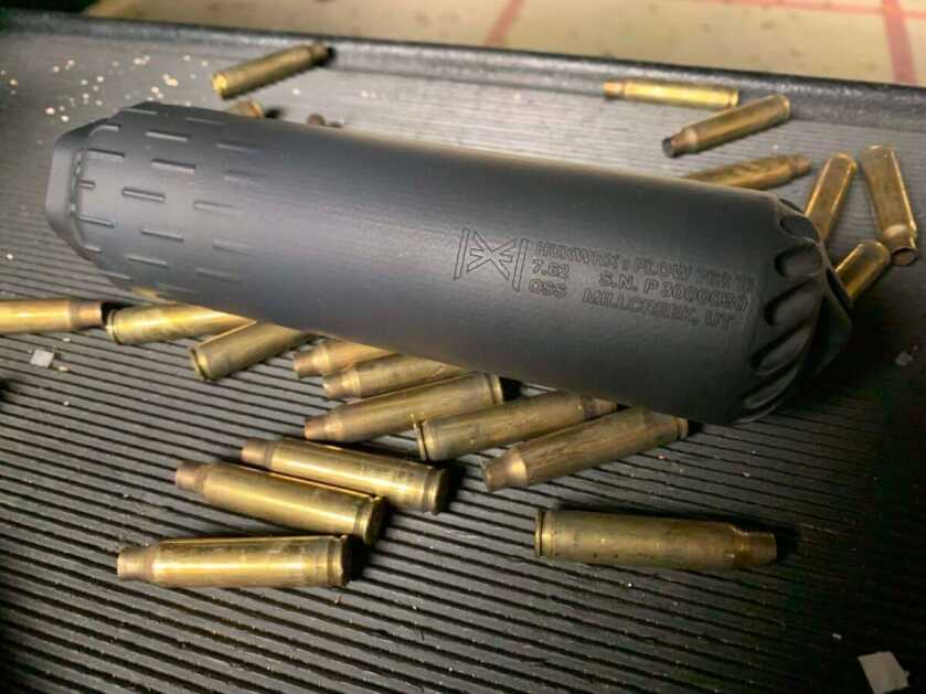 Flow 762 Ti suppressor sitting on the table surrounded in rifle brass.