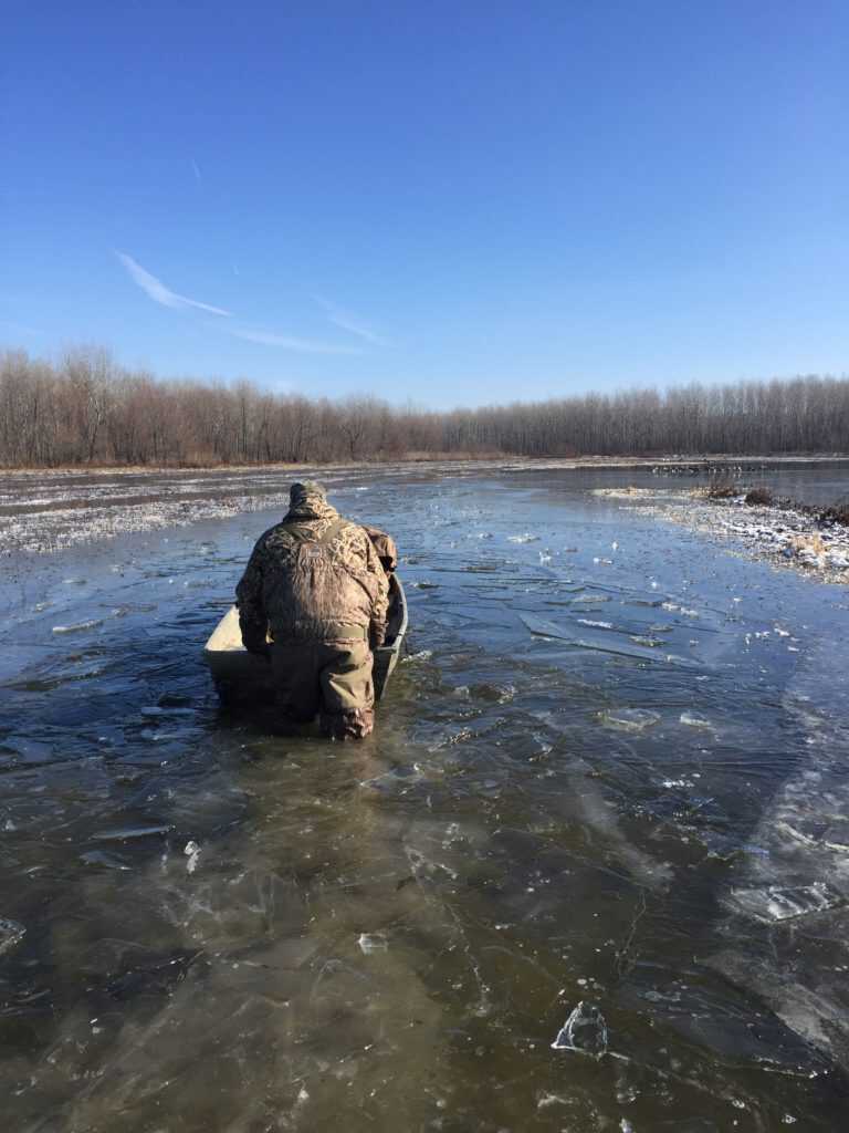 Hunter pushing gear through icy water