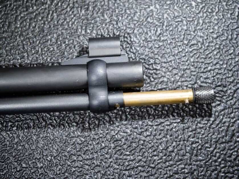 Close up of the end of the barrel and magazine with the brass magazine plunger partially removed.