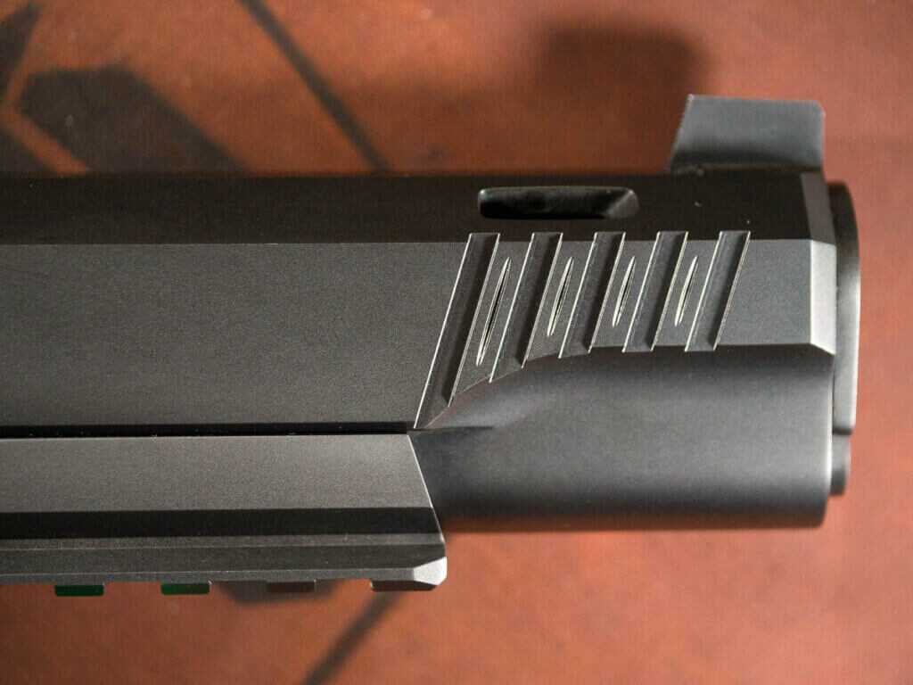 Close up view of the details at the front of the slide and dustcover. The gun is pointed to the right.