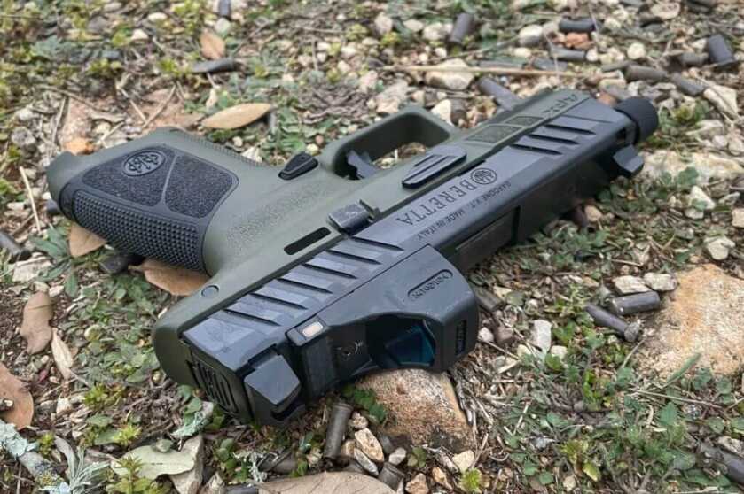 Beretta handgun with Holosun red dot on grass