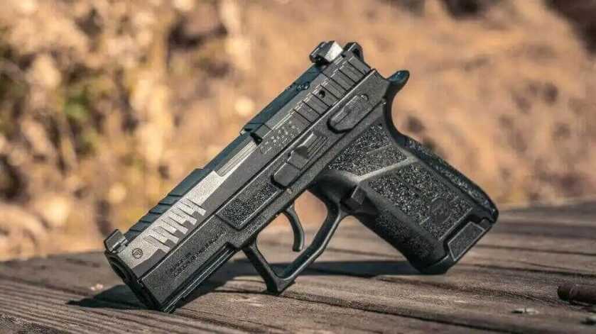 The CZ P-09 C Nocturne on a wooden table in warm light