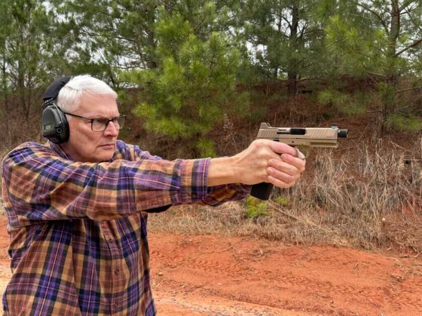 Man with hearing protection shooting the FN 545