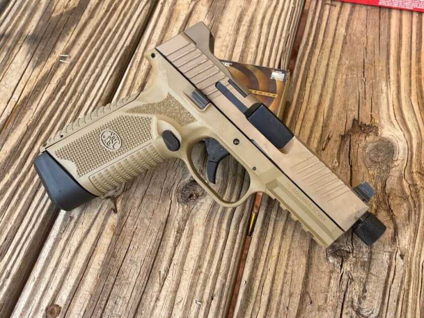 FN 545 handgun on wooden table