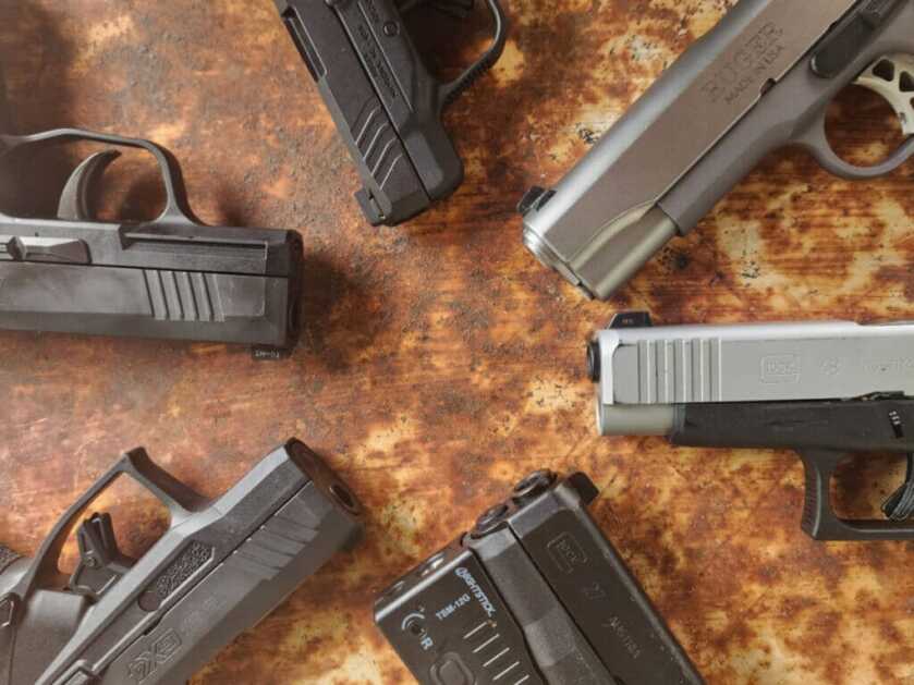 self-defense handguns in a circle on a table