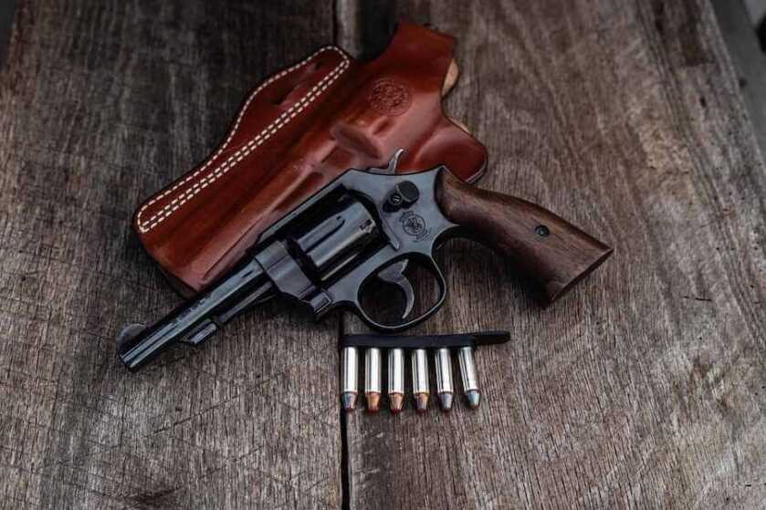 S&W revolver with no lock in front of a holster.