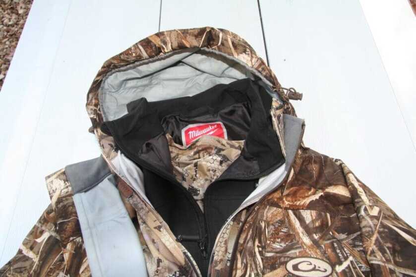 Complete hunting layering system laid out including base layer Milwaukee M12 heated vest and shell