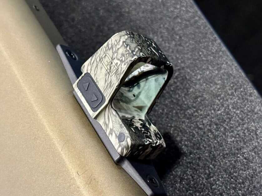 Side-profile of a red dot mounted on a shotgun.