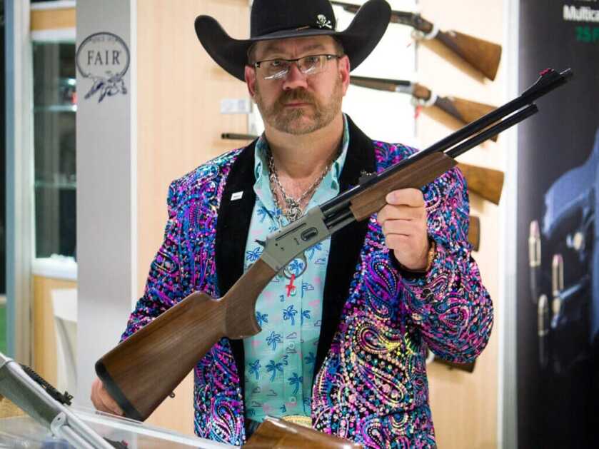 A cowboy holding the rifle.