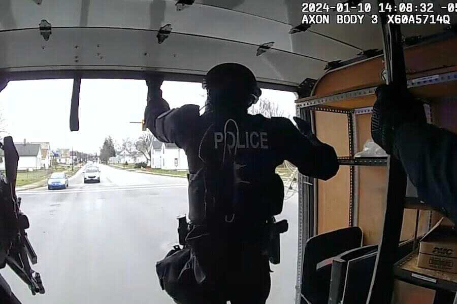 A police officer in the back of a raid rig.