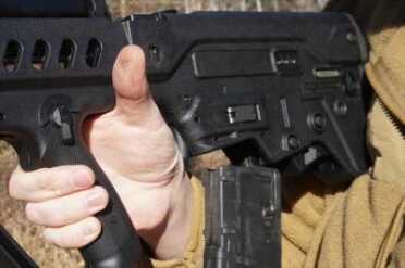 Mags drop free when the back of your hand hits this lever in front of the mag.