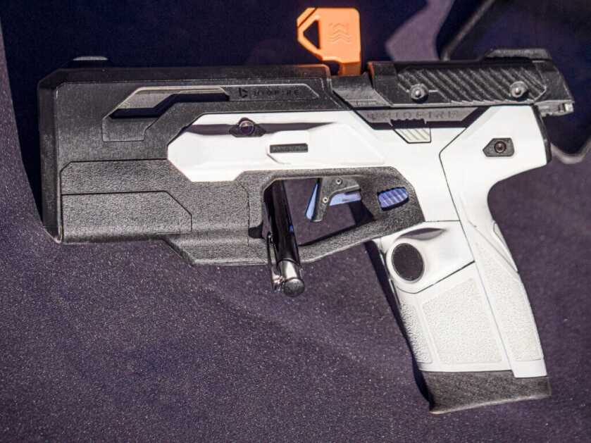 Biofire pistol laying on a table facing to the left.