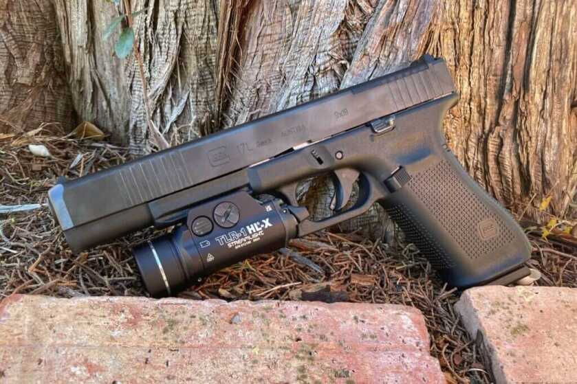 handgun sitting near bricks and tree stumps