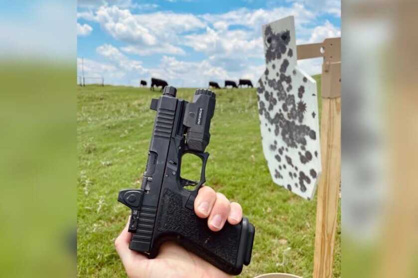 hand holding pistol in front of target 