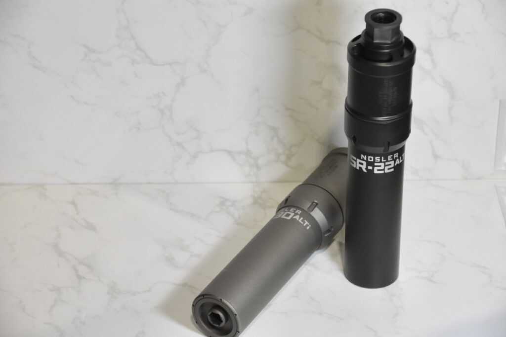 Two suppressors on a white backdrop.