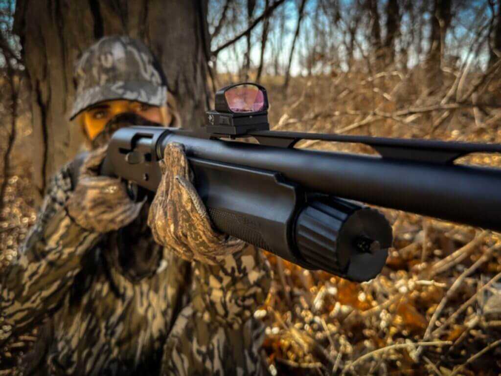 Hunter in the field with a shotgun featuring the Burris optic mount.