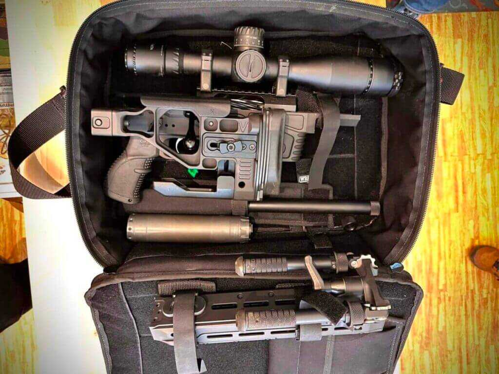 A rifle is taken apart and lies in a laptop case.