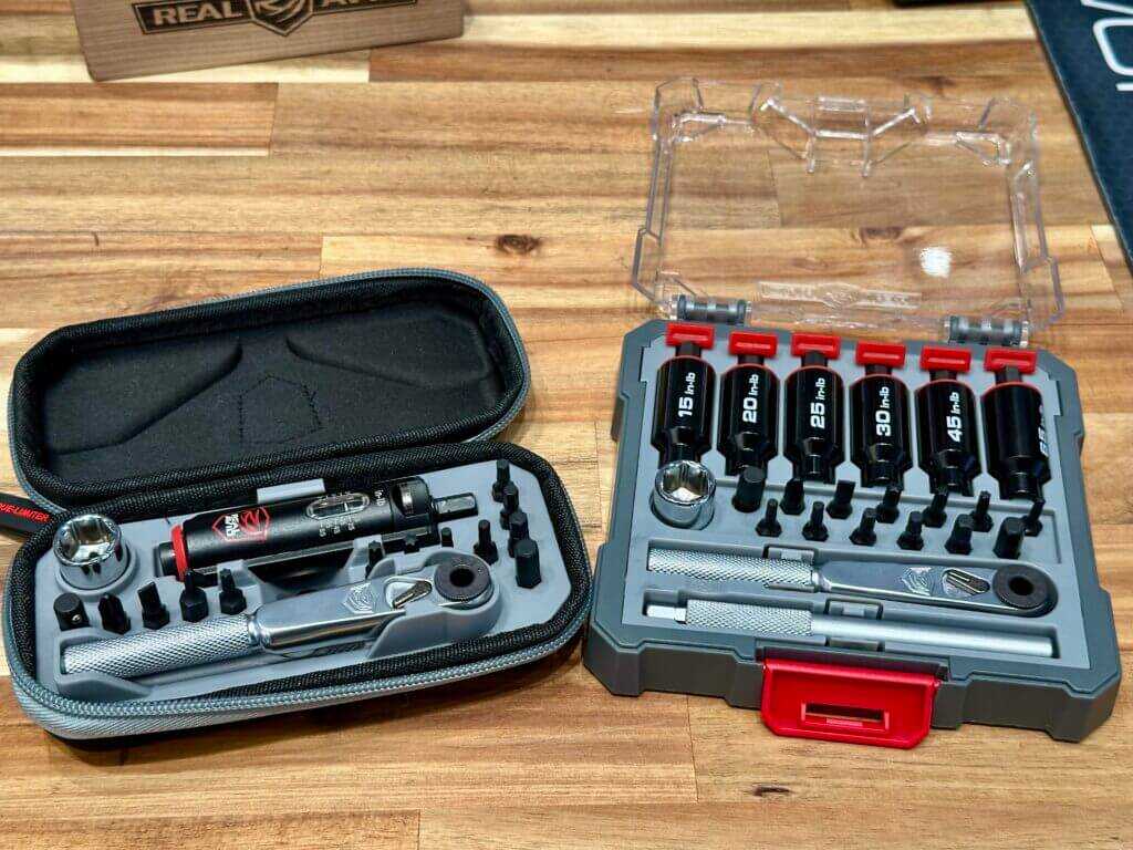 Two tool kits are on display on a wooden, butcher block table.