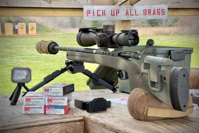 Savage 110 PPR at range with stack of Hornady Match ammo boxes