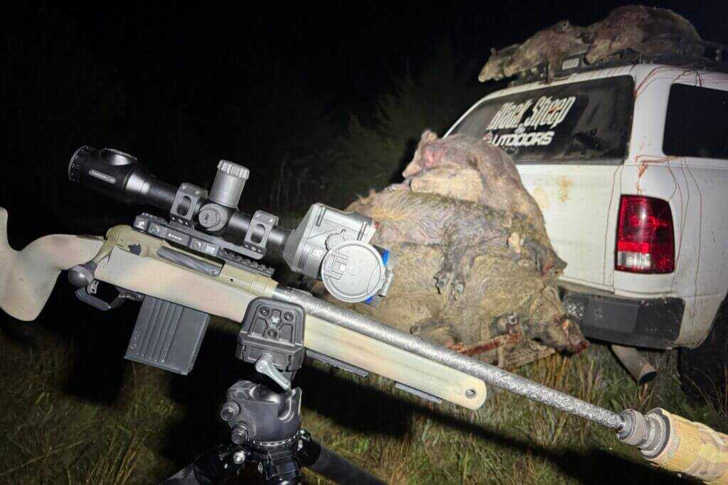 Vortex Pro Rifle Clamp with Savage 110 PPR and Pulsar Thermion 2 LRF XL60 in the dark with pile of wild hogs and white hunting truck