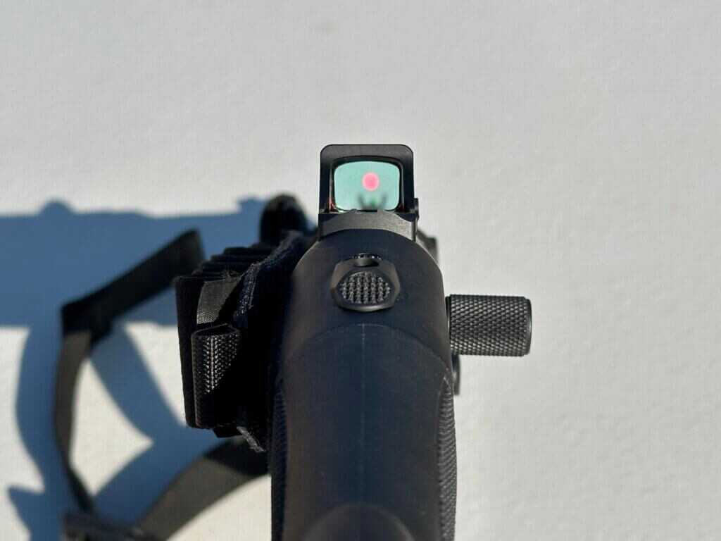 looking down the sights of a shotgun with a red dot optic mounted.
