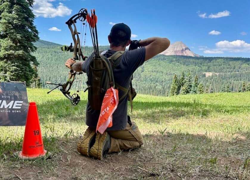 man kneeling with bow. index-finger release