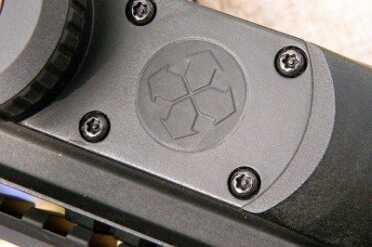 The sealed buttons behind the battery cap (arrows) are used to program the ballistic computer and to set illumination intensity.