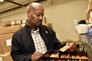 Zach Suber, Maryland State Police forensic scientist supervisor, holds an envelop containing casings in the files at the Maryland State Police Headquarters. (Photo: Kim Hairston, Baltimore Sun)