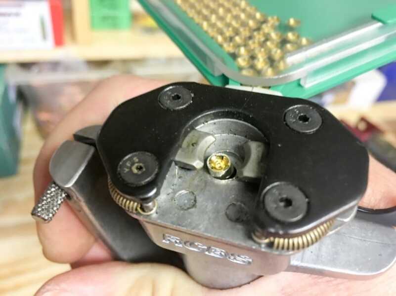 The squeeze action of hand priming tools drives a pistol up towards the primer pocket of a cartridge case.