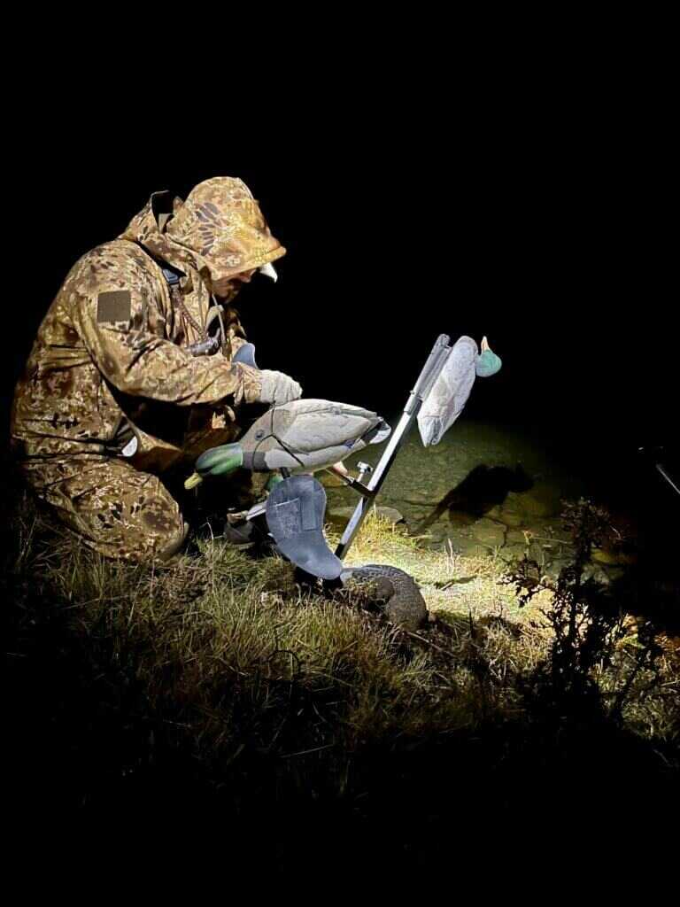 3-December-Kryptek Flyway Deadzone Review Dress for Success. Hunter setting up duck decoy in warm Kryptek gear