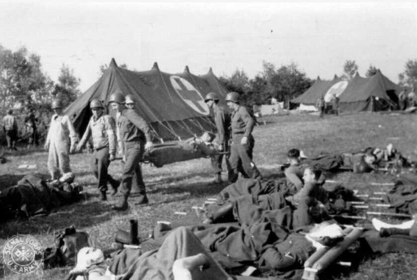 black and white photo of soldiers and medical staff in front of a medic tent
