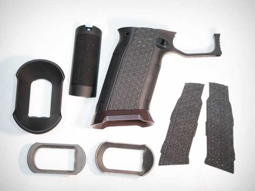 All the components of the grip module are laid out on the table.