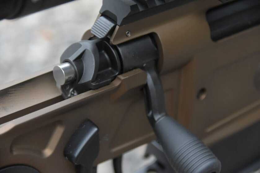 Closeup of a rifle's bolt shroud and safety.