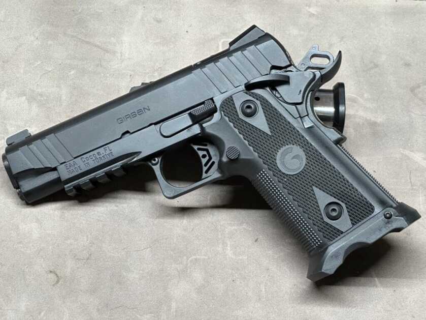 The Girsan Witness2311 is posed on a tan table top.