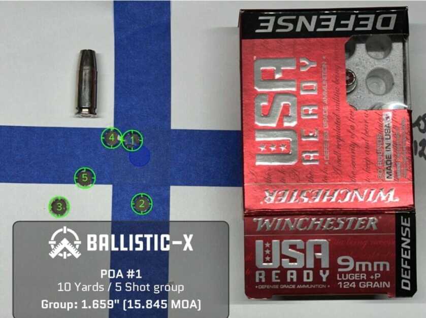 A paper target displays a 5 round group.