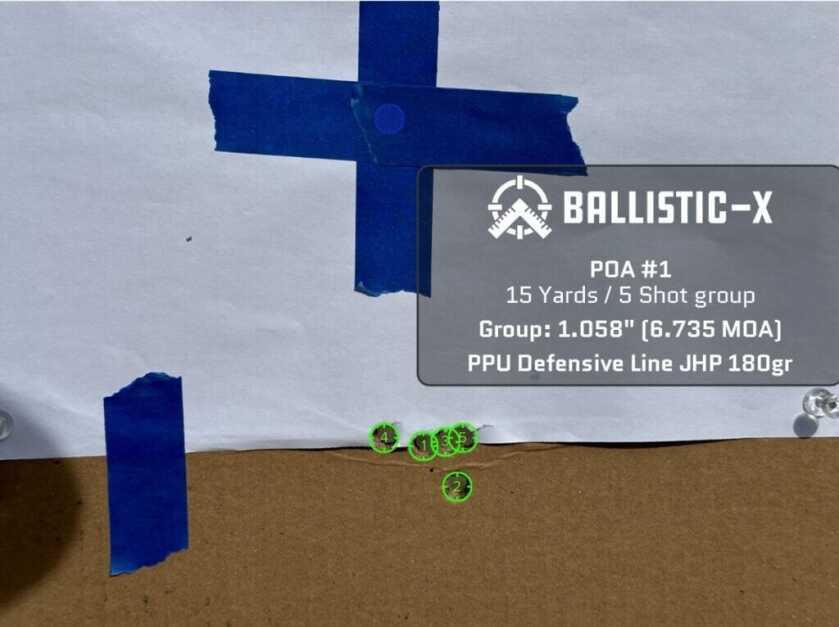 Five bullet holes are grouped on a target.