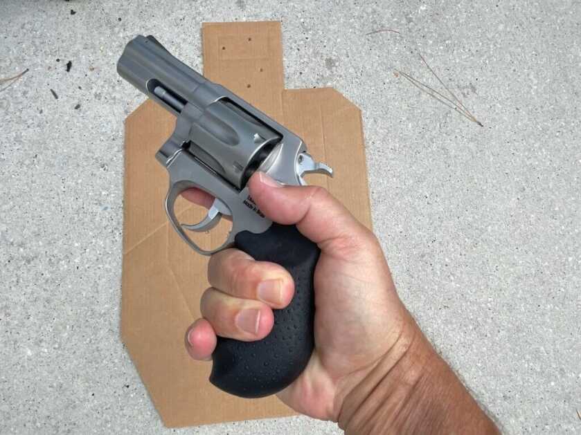 Revolver in hand next to cardboard target