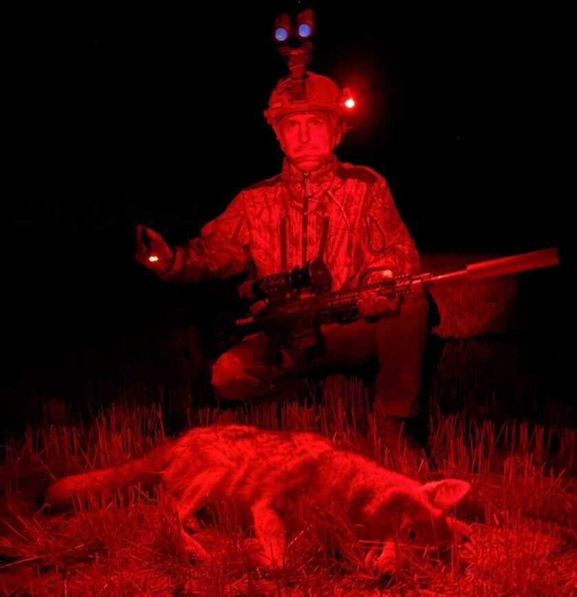 Hunter in red light using thermal gear for coyote hunting