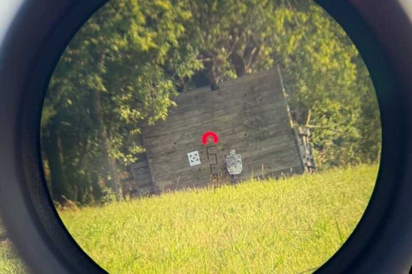 Looking through Arken scope at wooden fence and steel target
