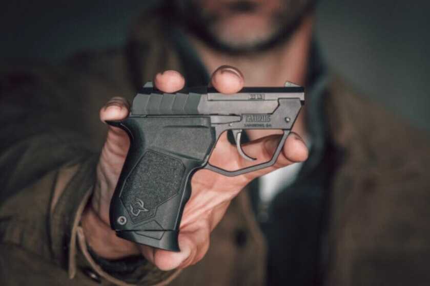 A man holding up a TUC22 pistol.
