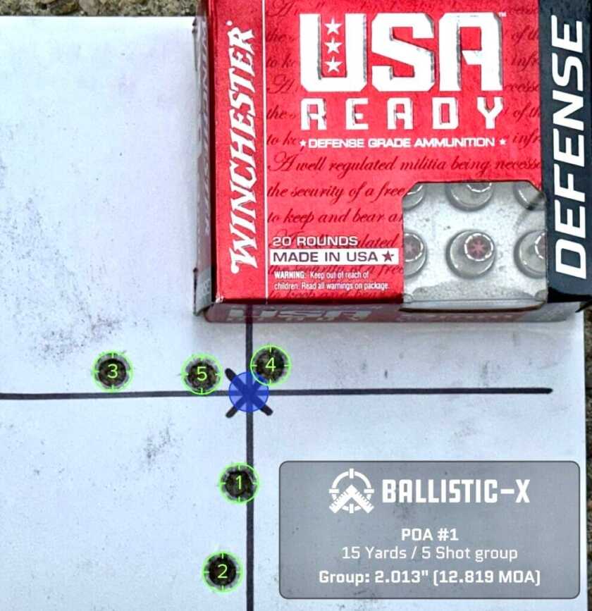 A used pistol target with a box of ammunition on top shows how accurate it is.