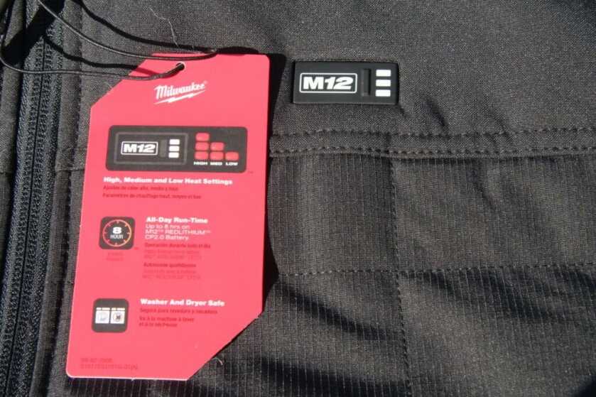Milwaukee M12 Axis heated vest closeup with product tag showing ripstop shell