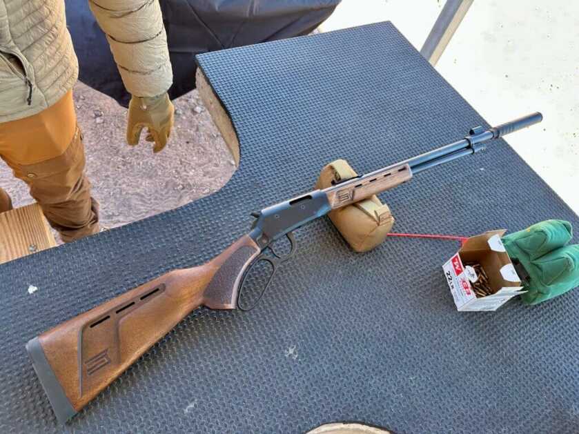 A lsuppressed ever action rifle rests on the table at the range.
