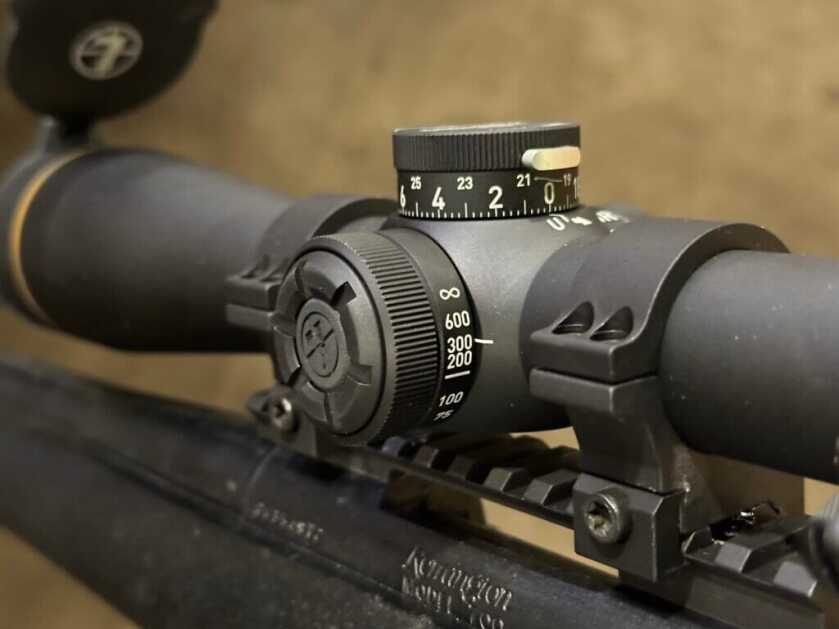 The parallax knob of the rifle scope is shown on the left side. you can also see the locking button on the elevation turret.