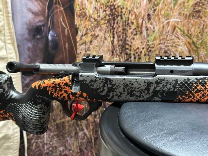 Closeup of a rifle action with its bolt open.