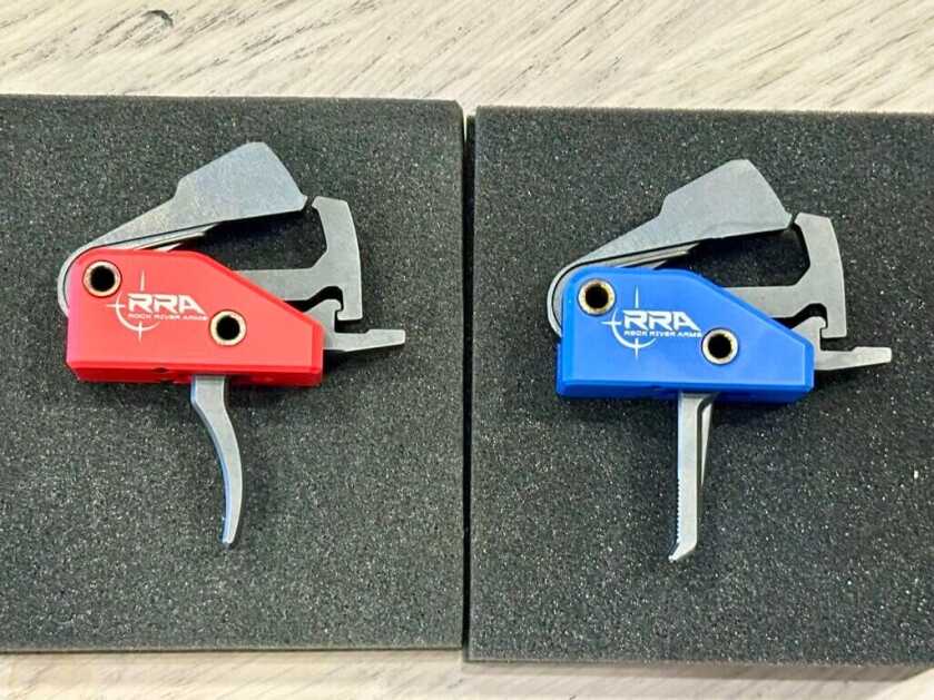 Rock River Arms drop in triggers displayed side-by-side. The red Duty Trigger is on the left and the Blue Precision trigger is on the right. 