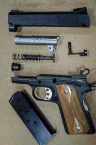 Field stripped, the DE1911U shows design elements like a barrel crown and dual recoil springs.