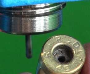 The first die resizes the case and "decaps" it by poking out the old primer with a hard rod.