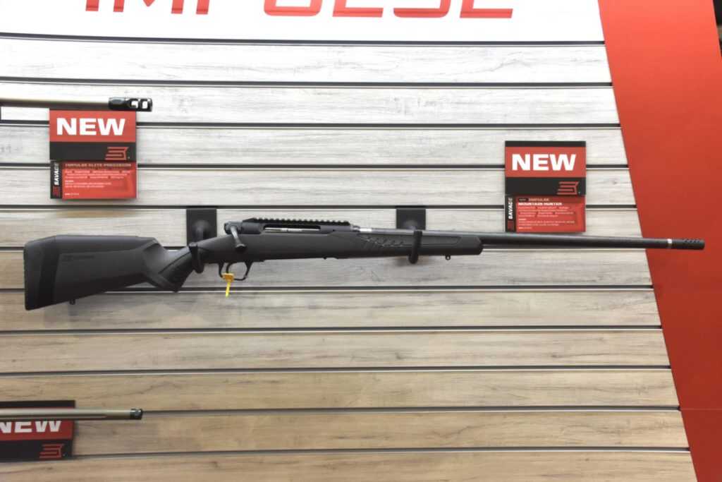 a bolt-action rifle hangs on a wall for display.