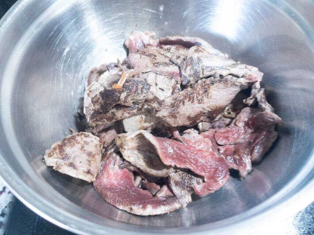 seared thinly sliced meat in a bowl.